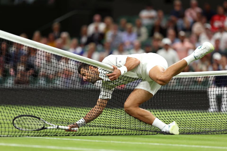 Novak Djokovic falls over the net against Hubert Hurkacz of Poland in the Men's Singles fourth round match on July 9, 2023 in London, England.