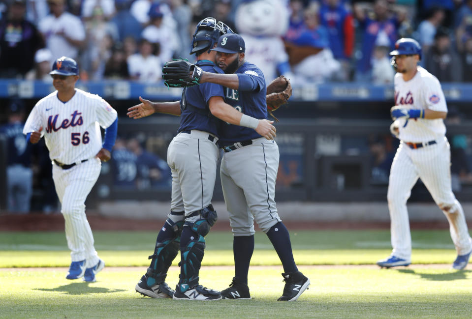 Seattle Mariners catcher Cal Raleigh and relief pitcher Diego Castillo celebrate after defeating the New York Mets 8-7 during a baseball game, Sunday, May 15, 2022, in New York. (AP Photo/Noah K. Murray)