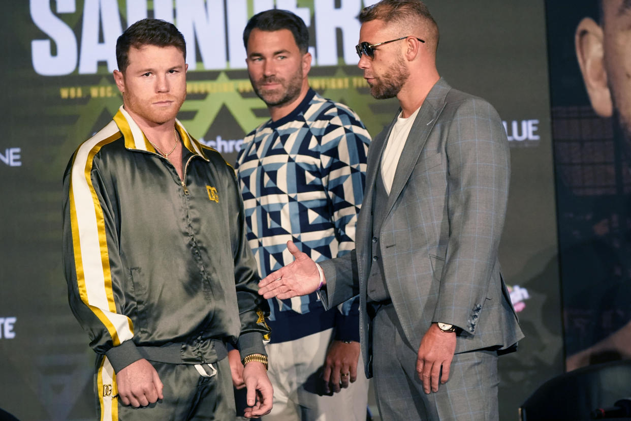 Canelo Alvarez of Mexico, left, turns away as Billy Joe Saunders of Great Britain, right, offer to shake hands with promoter Eddie Hearn looking on during a pre-fight news conference, Thursday, May 6, 2021, in Arlington, Texas. Alvarez and Saunders fight on Saturday, May 8, 2021, for the unified super middleweight world championship. (AP Photo/LM Otero)