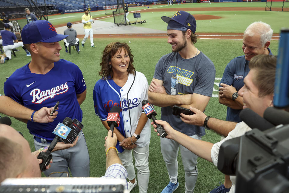 Texas Rangers' Nathaniel Lowe, left, and Tampa Bay Rays' Josh Lowe, third from left, talk to the media along with their parents Wendy Lowe, second from left, and David Lowe, back right, prior to a baseball game June 9, 2023, in St. Petersburg, Fla. There is a Lowe family reunion this weekend in Texas, where Wendy is getting to watch her sons play against each other for the first time since being diagnosed with brain cancer last year. (AP Photo/Mike Carlson, File)