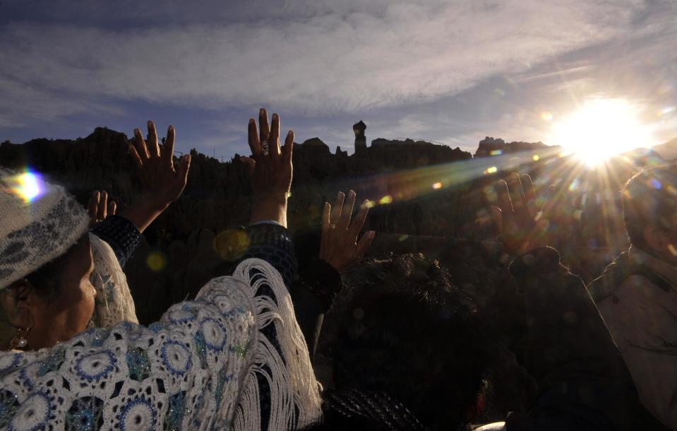 Aymara natives raise their hands at sunrise during the celebration of the winter solstice near La Paz, Bolivia in 2012.  / Credit: AIZAR RALDES via Getty Images