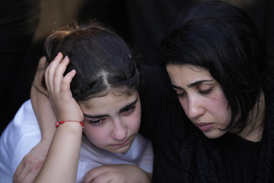 Friends and relatives attend the funeral of people who died in a fire during a wedding ceremony in Hamdaniya, Iraq, Wednesday, Oct. 27, 2023. A fire that raced through a hall hosting a Christian wedding in northern Iraq has killed around 100 people and injured 150 others, and authorities warn the death toll could rise. (AP Photo/Hadi Mizban