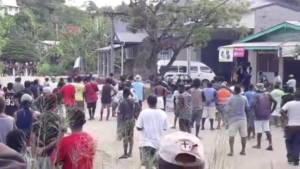 People gather near Naha police station as islanders defy curfew in the capital (Reuters)