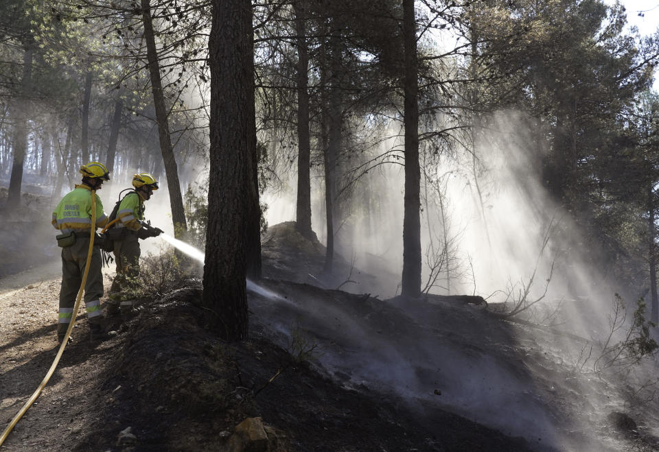 Firefighters try to extinguish a forest fire in Fuente la Reina, Castellon de la Plana, Spain, March 29, 2023. A prolonged drought after a record-hot 2022 appears to have brought the wildfire season forward and Spanish officials are now bracing for more huge fires. (AP Photo/Alberto Saiz)