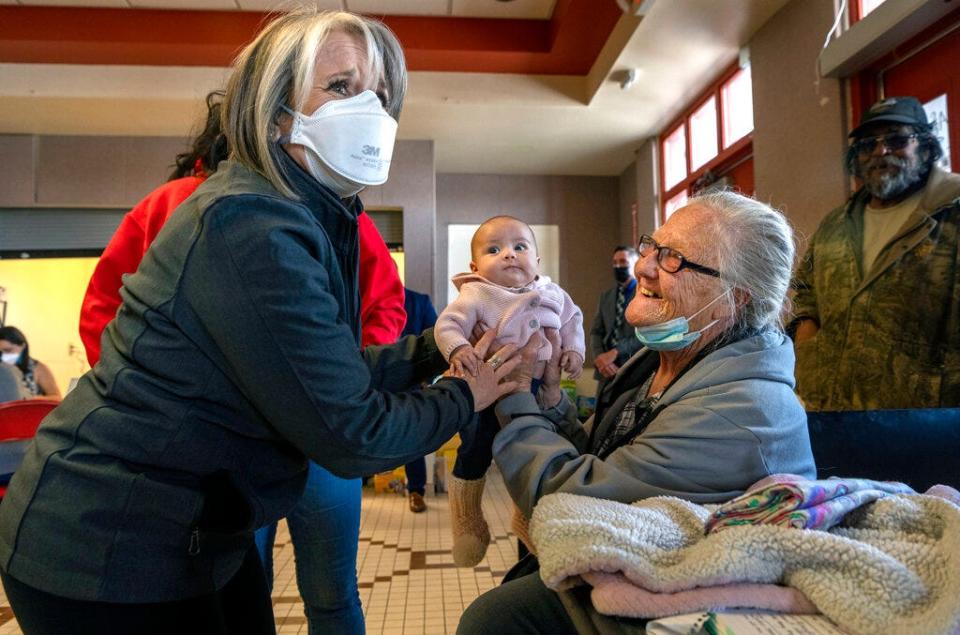 New Mexico Gov. Michelle Lujan Grisham, left, wears a mask while greeting Connie Guinn and her granddaughter, Bella Guerrero Muñoz, at an emergency evacuation center in Las Vegas, Monday April 25, 2022.  The two had been evacuated from the Calf Canyon Fire.