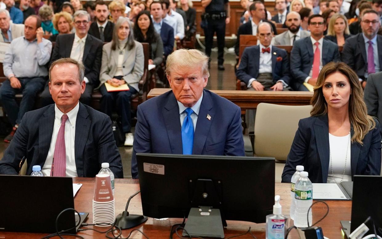 Former President Donald Trump, center, sits in a New York court
