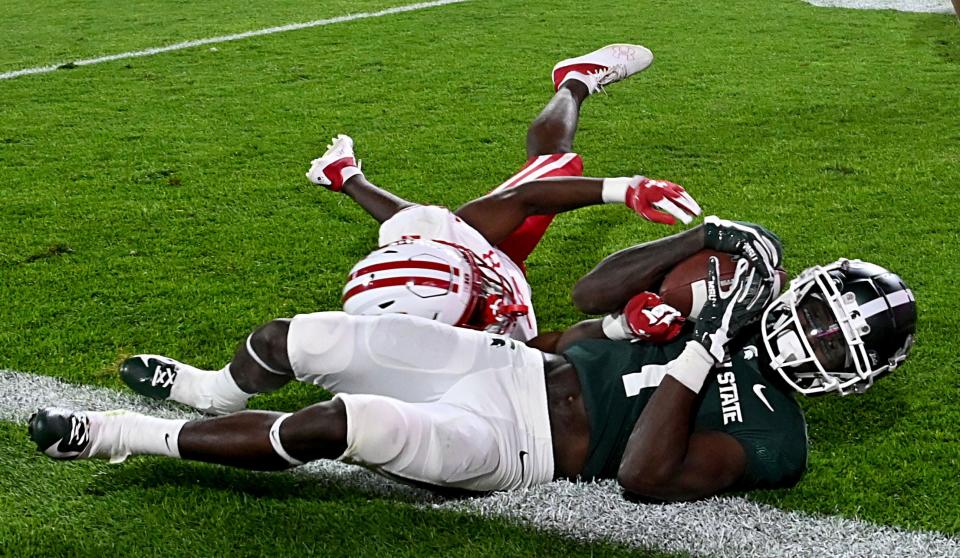 Michigan State wide receiver Jayden Reed catches a touchdown pass in spite of Wisconsin cornerback Ricardo Hallman in a second overtime period of MSU's 34-28 win on Saturday, Oct. 15, 2022, in East Lansing.