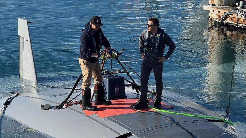 Defense Advanced Research Projects Agency program manager Kyle Woerner (right) talks with a member of the Northrop Grumman team while standing atop the Manta Ray vehicle. - Defense Advanced Research Projects Agency