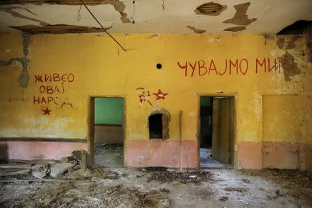 Communist-era signs are seen on a wall inside an abandoned local community house in the village of Aldinac, near the south-eastern town of Knjazevac, Serbia, August 15, 2016. The writings read: "Long live this nation" (L) and "Keep the peace". (R). REUTERS/Marko Djurica