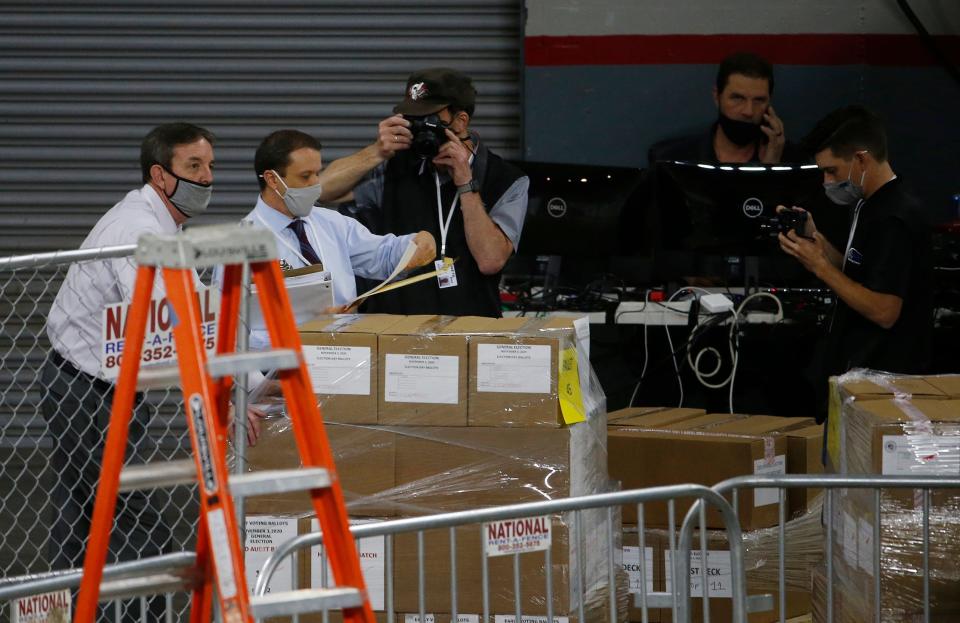 Former Arizona Secretary of State Ken Bennett (left) takes custody of a pallet of ballots before an audit of the 2.1 million election ballots at Veterans Memorial Coliseum in Phoenix on April 22, 2021.