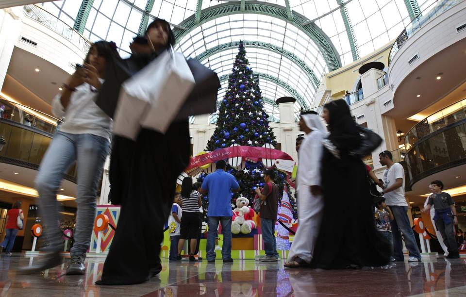 FILE- in This Wednesday, Dec. 23, 2009 file photo, Emirati couple and the other nationalities pass by a giant Christmas tree at a shopping mall in Dubai, United Arab Emirates. The United Arab Emirates has been embarking on a yearlong, nationwide project to promote and brand state efforts under theme of "tolerance", but as 2019 inevitably comes to an end, a leading Emirati diplomat said Wednesday there's still much more work to be done. (AP Photo/Kamran Jebreili, File)