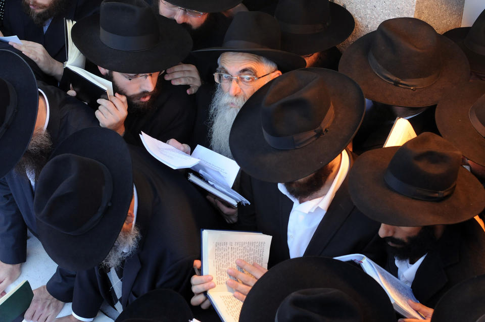 In this photo provided by Chabad.org, Chabad-Lubavitch rabbis reflect at the grave site of the Lubavitcher Rebbe, Rabbi Menachem M. Schneerson, who died in 1994, in the Queens borough of New York on Friday, Nov. 25, 2011. The rabbis were among nearly 4,000 rabbis from around the world in New York for the International Conference of Chabad-Lubavitch Emissaries, an annual event aimed at reviving Jewish awareness and practice around the world. (AP Photo/Chabad.org, Jonathan Alpeyrie)