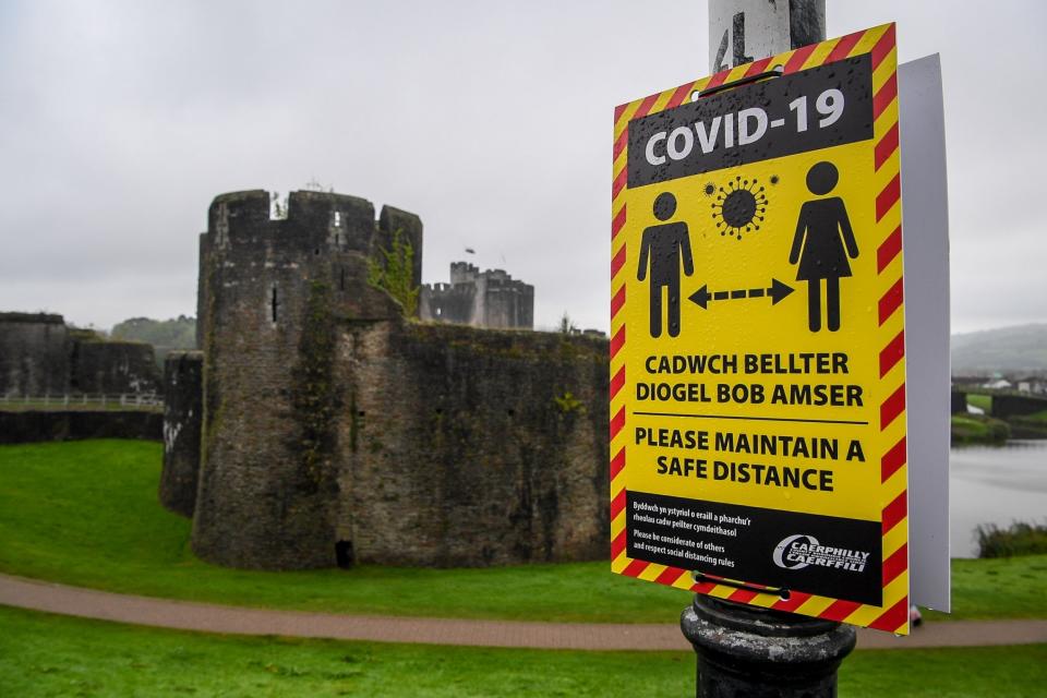 Covid-19 signage opposite Caerphilly castle advises on social distancing as the county borough in south Wales is to be placed under a local lockdown (PA)