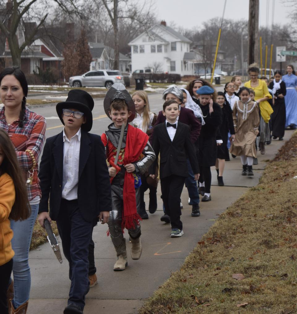 Students from Cornerstone Classical School walk along Ninth Street dressed as Kansas historical figures. The promenade of students was part of Kansas Day celebrations the school had Friday.