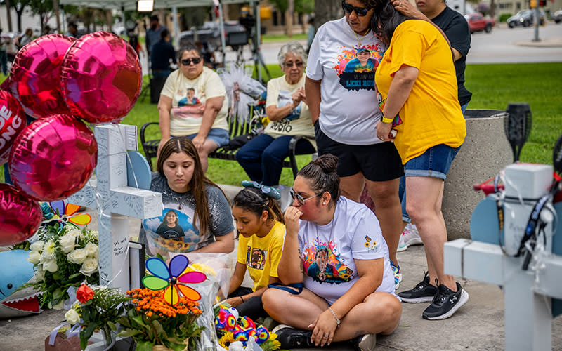 A family pays their respects at a memorial dedicated to the 19 children and two adults murdered during a shooting in Uvalde, Texas a year ago
