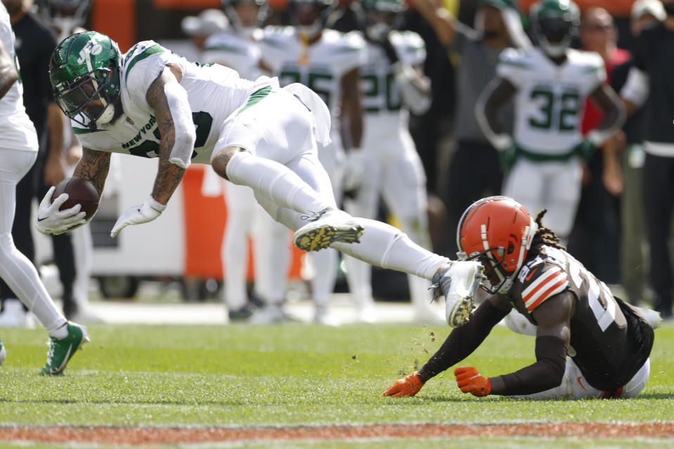 New York Jets tight end Tyler Conklin, left, is tackled by Cleveland Browns cornerback Martin Emerson Jr., right, after making a catch during the second half of an NFL football game, Sunday, Sept. 18, 2022, in Cleveland. (AP Photo/Ron Schwane)