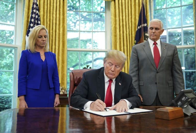 US President Donald Trump signs an executive order ending a policy of separating families caught crossing the US-Mexico border illegally