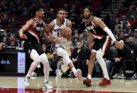 Sacramento Kings forward Keegan Murray, center, drives to the basket past Portland Trail Blazers guard Shaedon Sharpe, left, and forward Trendon Watford, right, during the first half of an NBA basketball game in Portland, Ore., Friday, March 31, 2023. (AP Photo/Steve Dykes)