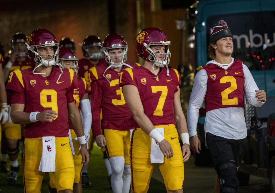 USC quarterbacks Kedon Slovis (9), Miller Moss (7) and Jaxson Dart (2) walk onto the field.