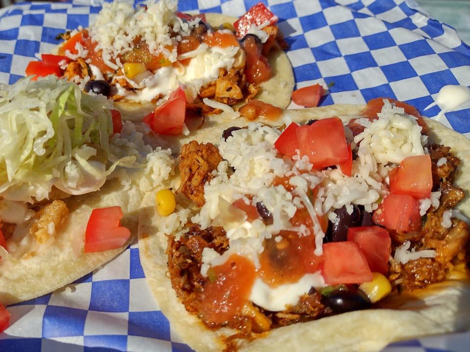 shot of two open burritos on a blue and white checkered tablecloth