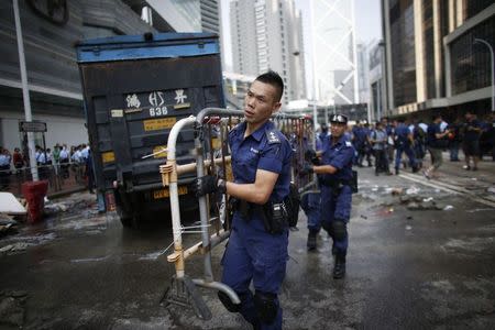 Police remove a barricade at a protest site in Admiralty near the government headquarters in Hong Kong October 14, 2014. REUTERS/Carlos Barria