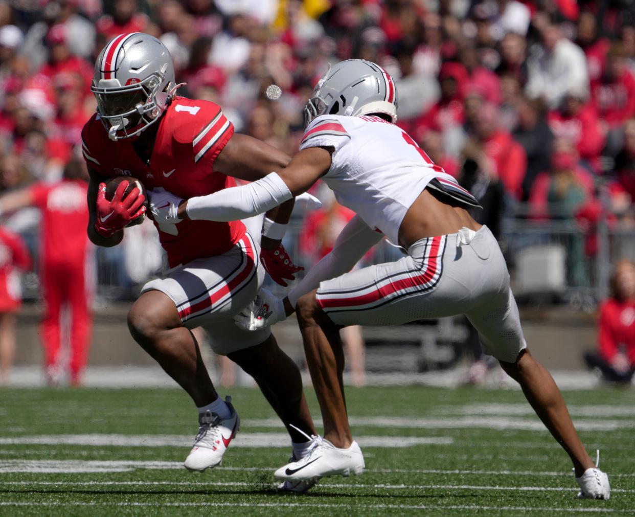 April 13, 2024; Columbus, Ohio, USA; 
Ohio State Buckeyes running back Quinshon Judkins (1) of the scarlet team is tagged by cornerback Davison Igbinosun (1) of the grey team during the first half of the LifeSports spring football game at Ohio Stadium on Saturday.