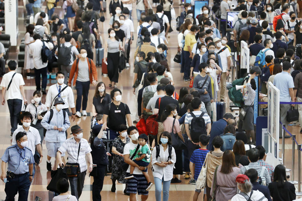 Travelers wearing face masks crowd at Haneda airport in Tokyo Saturday, Sept. 19, 2020, on the first day of the 4-day holiday. (Kyodo News via AP)