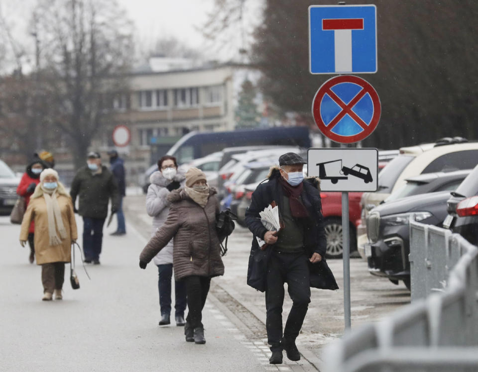 Elderly people arrive to be vaccinated against COVID-19 at the temporary hospital at the National Stadium in Warsaw, Poland, on Monday, Jan. 25, 2021. Overload of online registration system and reduced deliveries of the Pfizer vaccines are causing delays in the national inoculation procedure that currently aims at vaccinating people aged over 70. (AP Photo/Czarek Sokolowski)