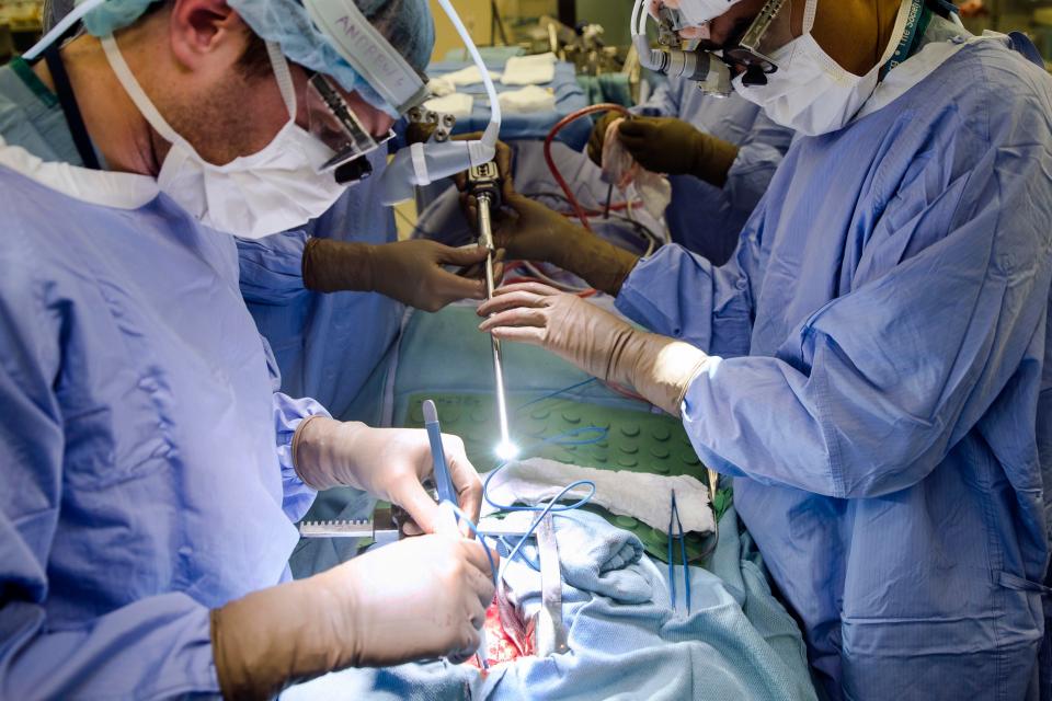 In this Tuesday, Jan. 23, 2018 file photo, a surgeon directs a special camera to be able to view his patient's cancer tumor on monitors while performing surgery at a hospital in Philadelphia. As the COVID-19 coronavirus spreads, many cancer surgeries are being delayed, stent procedures for clogged arteries have been pushed back and infertility specialists were asked to postpone helping patients get pregnant.