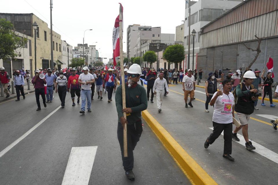 Anti-government protesters march in Lima, Peru, Friday, Jan. 20, 2023. Protesters are seeking the resignation of President Dina Boluarte, the release from prison of ousted President Pedro Castillo and immediate elections. (AP Photo/Guadalupe Pardo)