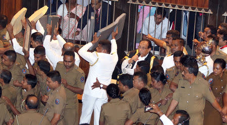 Sri Lanka's police members protect parliament speaker Karu Jayasuriya (in a black jacket, C) as he tries to walk to his chair while parliament members who are backing newly appointed Prime Minister Mahinda Rajapaksa protest during the parliament session in Colombo, Sri Lanka November 16, 2018. REUTERS/Stringer