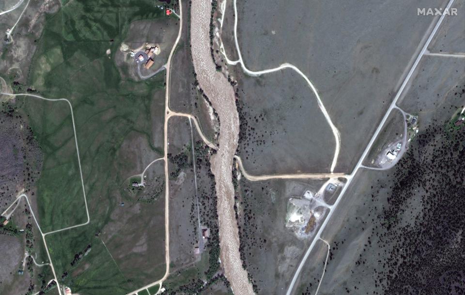 satellite image white gray brown swollen yellowstone river with road bridge gone