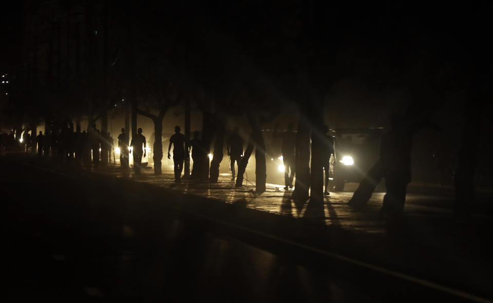 People hang out on a dark street due to damaged electricity supply in Beira, Mozambique, Monday, March 25, 2019. (AP Photo/Themba Hadebe)