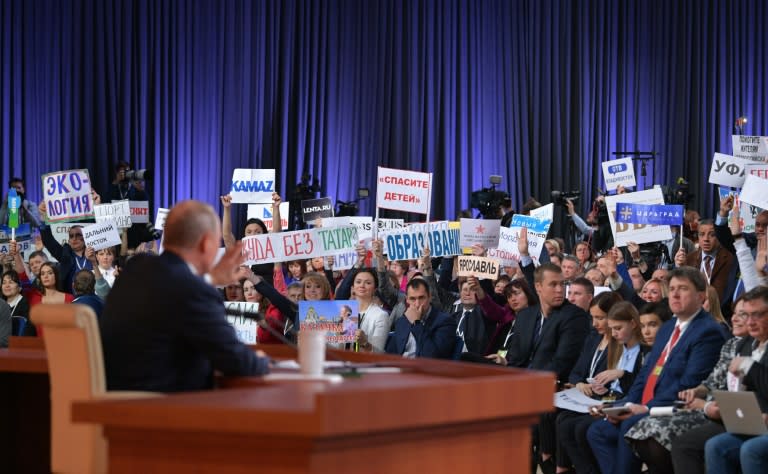 Journalists hold up signs to indicate the nature of their question at Putin's press conference