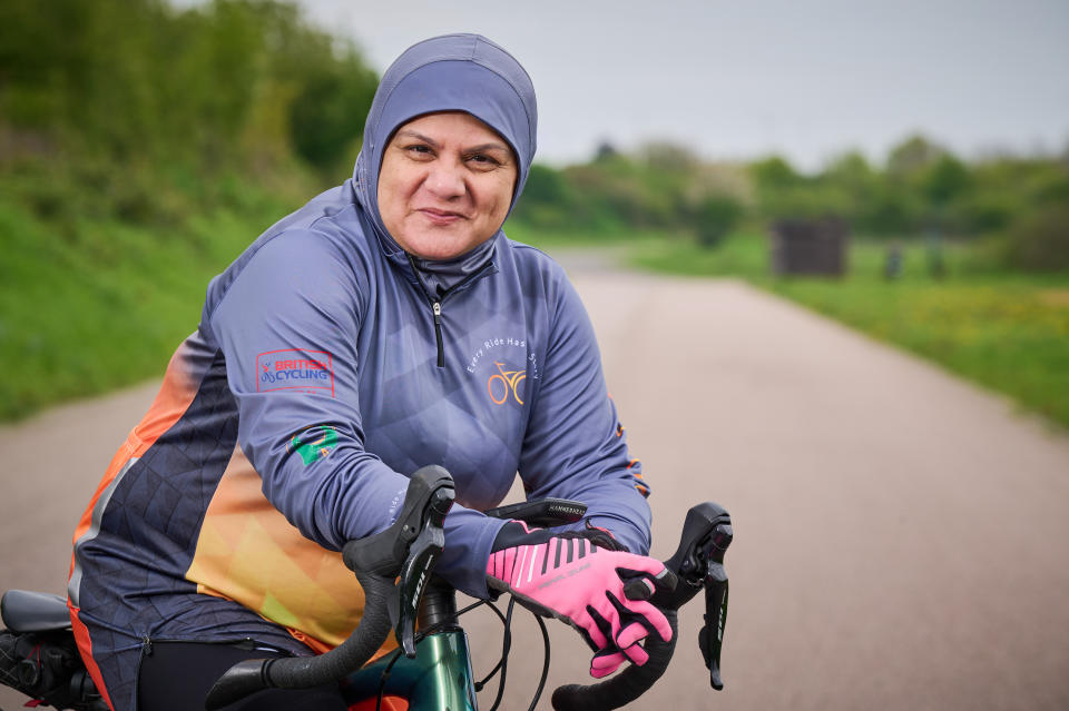 A close-up of Iffat Tejani, standing, leaning on the handlebars of his bike