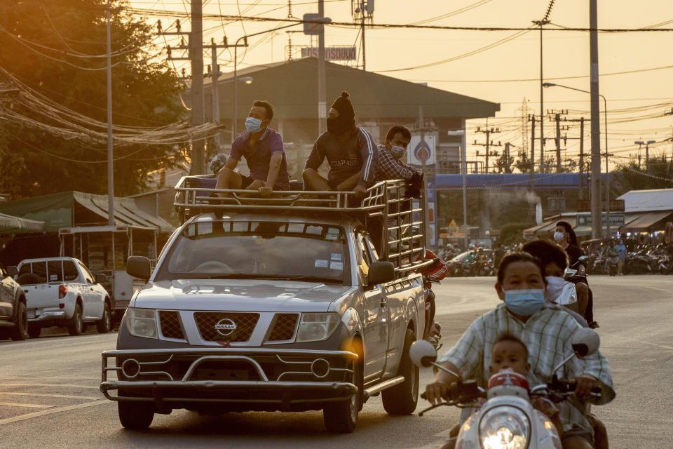 Migrant workers travel in atop of a trucks in Samut Sakhon, South of Bangkok, Thailand, Monday, Jan. 4, 2021. For much of 2020, Thailand had the coronavirus under control. After a strict nationwide lockdown in April and May, the number of new local infections dropped to zero, where they remained for the next six months. However, a new outbreak discovered in mid-December threatens to put Thailand back where it was in the toughest days of early 2020. (AP Photo/Gemunu Amarasinghe)