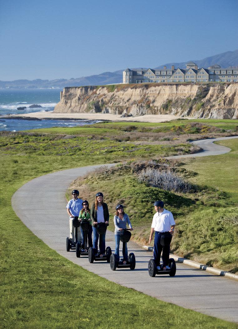 This 2010 photo provided by the Ritz-Carlton Half-Moon Bay shows a hotel recreational staff member leading a group of hotel guests on a Segway tour of the Coastal Trail in Half-Moon Bay, Calif., on the Pacific Ocean with the hotel property on a nearby cliff. A number of hotels offer Segway tours as a novel way to see their grounds and nearby scenic areas. (AP Photo/Ritz-Carlton)