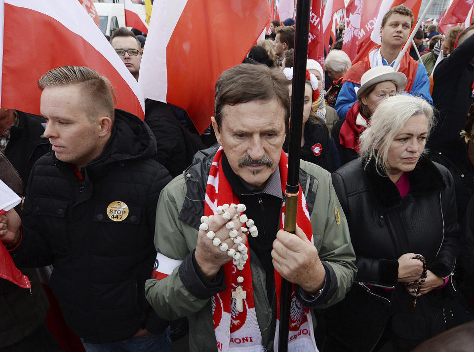 Men pray with rosaries before a march on Independence Day in Warsaw, Poland, Monday, Nov. 11, 2019. (AP Photo/Czarek Sokolowski)