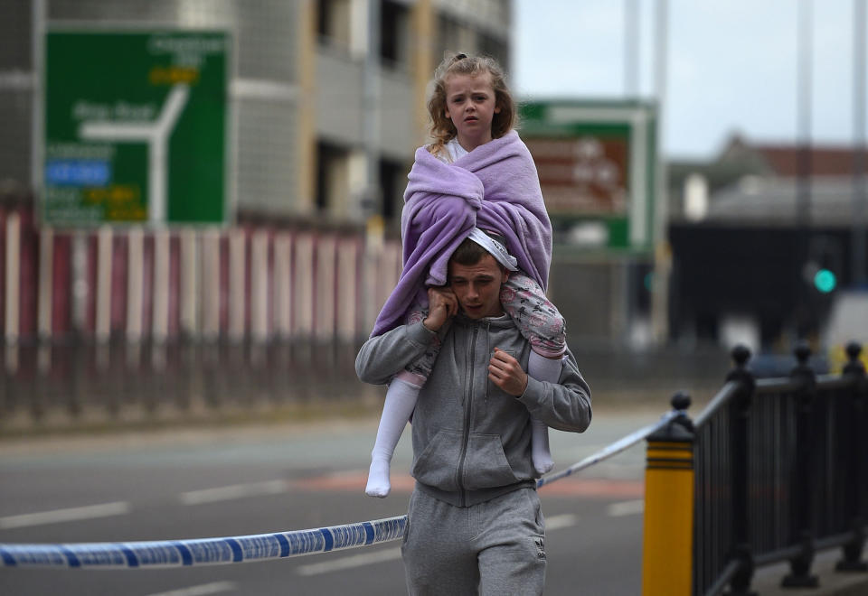 <p>A man carries a young girl on his shoulders near Victoria station in Manchester, northwest England on May 23, 2017. (Oli Scarff/AFP/Getty Images) </p>