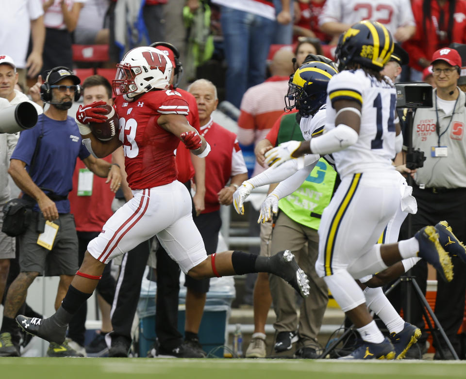 Wisconsin running back Jonathan Taylor make a first-down run against Michigan defensive back Brad Hawkins and defensive back Josh Metellus during the first half of an NCAA college football game Saturday, Sept. 21, 2019, in Madison, Wis. (AP Photo/Andy Manis)