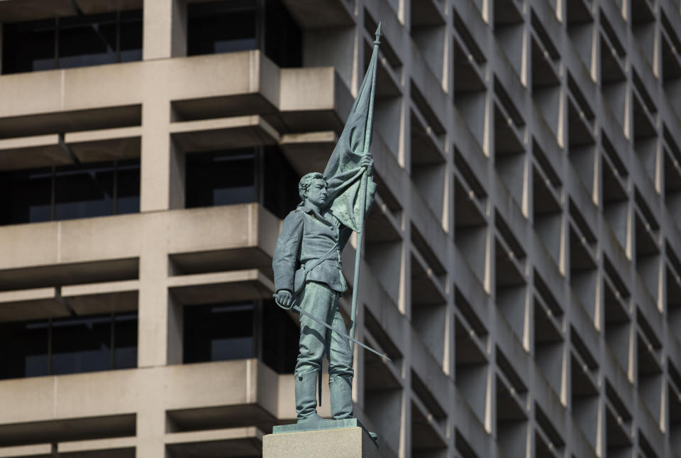 File-This June 25, 2015, file photo shows the 15-foot figure of a Confederate soldier on top of a Norfolk monument commemorating the last reunion of surviving confederate soldiers. Virginia’s second largest city is suing the state in an attempt to remove an 80-foot-tall Confederate monument from its downtown. The city of Norfolk’s suit was filed Monday, Aug. 19, 2019, in federal court and targets a Virginia law that prevents the removal of war memorials. (Bill Tiernan/The Virginian-Pilot via AP, File)