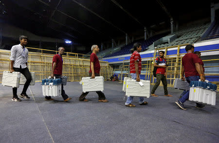 FILE PHOTO: Members of election staff carry Electronic Voting Machines (EVM) and Voter Verifiable Paper Audit Trail (VVPAT) machines after collecting them from a distribution centre at an indoor stadium ahead of the seventh and last phase of general election, in Kolkata, India, May 18, 2019. REUTERS/Rupak De Chowdhuri/File Photo