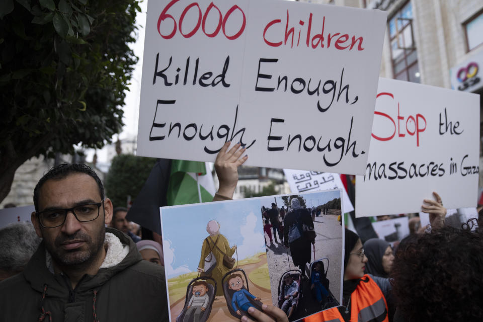 Palestinian protesters carry posters and chant anti Israel slogans during a rally in solidarity with Gaza, in the West Bank city of Ramallah, Wednesday, Nov. 22, 2023. (AP Photo/Nasser Nasser)