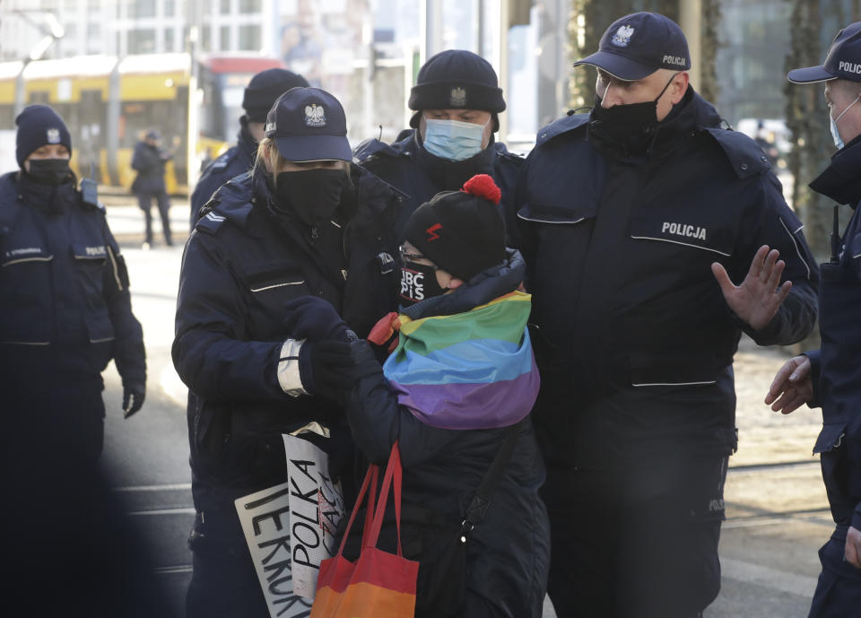 Police block a protester, Katarzyna Augustynek, who is widely known as "Grandma Kasia," during a Women's Day protest in in Warsaw, Poland, Monday March 8, 2021. Women’s rights activists in Poland marked International Women’s Day on Monday caught between reasons to celebrate and a heavy sense that they are facing a long battle ahead. This year’s Women’s Day, which is being marked with protests, comes after a near total ban on abortion took effect in January in the historically Roman Catholic country, a step that had long been been sought by the conservative ruling party, Law and Justice. (AP Photo/Czarek Sokolowski)