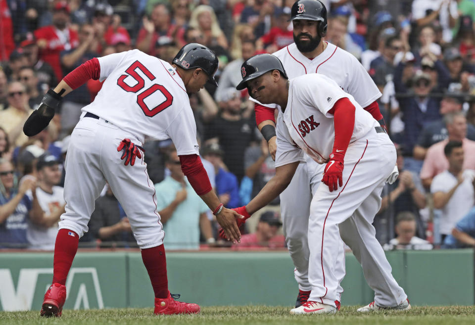 Boston Red Sox's Rafael Devers, right, is congratulated by Mookie Betts after hitting a three-run home run during the fifth inning of a baseball game against the Toronto Blue Jays at Fenway Park in Boston, Thursday, July 18, 2019. (AP Photo/Charles Krupa)