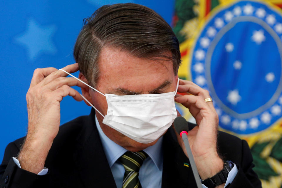 Brazil's Jair Bolsonaro adjusts his protective face mask during a news conference to announce measures to curb the spread of the coronavirus disease (COVID-19) in Brasilia, Brazil March 18, 2020. REUTERS/Adriano Machado     TPX IMAGES OF THE DAY