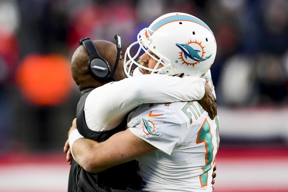 Ryan Fitzpatrick and Brian Flores celebrate a game-winning touchdown pass against the New England Patriots in the season finale last year. (Photo by Billie Weiss/Getty Images)