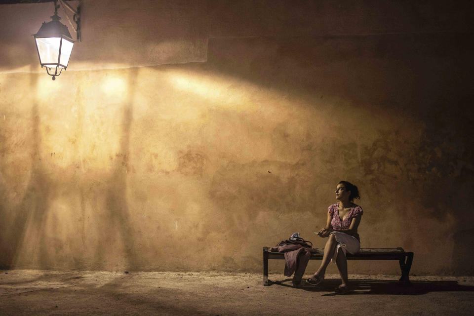 A woman poses for a photo while resting on a bench in the Kasbah of Oudayas, a 12th century fortress overlooking the Atlantic Ocean, in Rabat, Morocco, Tuesday, Sept. 22, 2020. (AP Photo/Mosa'ab Elshamy)