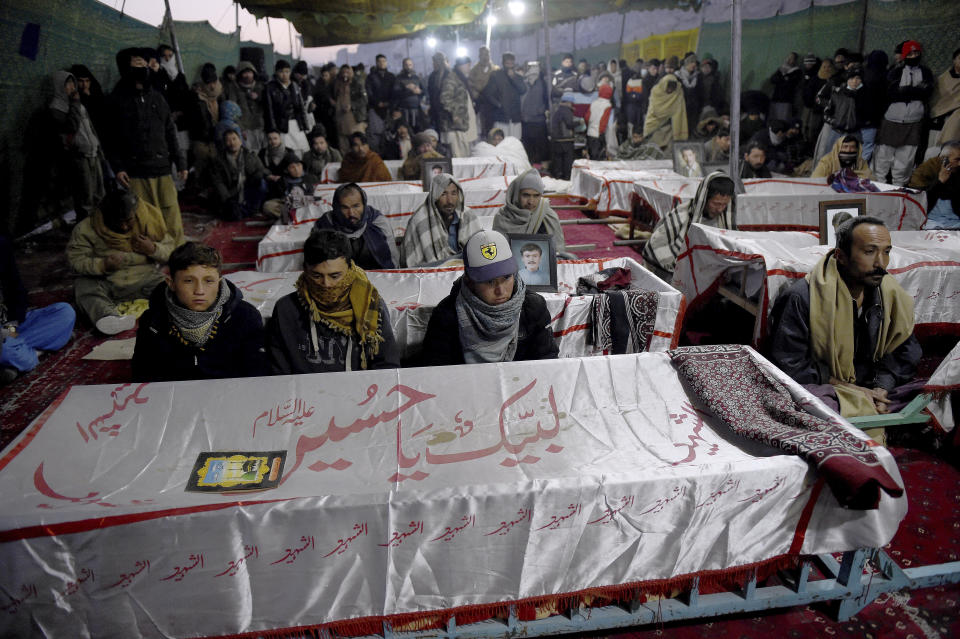 People from the Shiite Hazara community gather around coffins of coal mine workers killed by gunmen near the Machh coal field, during a sit-in to protest, in Quetta, Pakistan, Friday, Jan. 8, 2021. Pakistan's prime minister Friday appealed the protesting minority Shiites not to link the burial of 11 coal miners from Hazara community who were killed by the Islamic State group to his visit to the mourners, saying such a demand amounted to blackmailing the country's premier. (AP Photo/Arshad Butt)