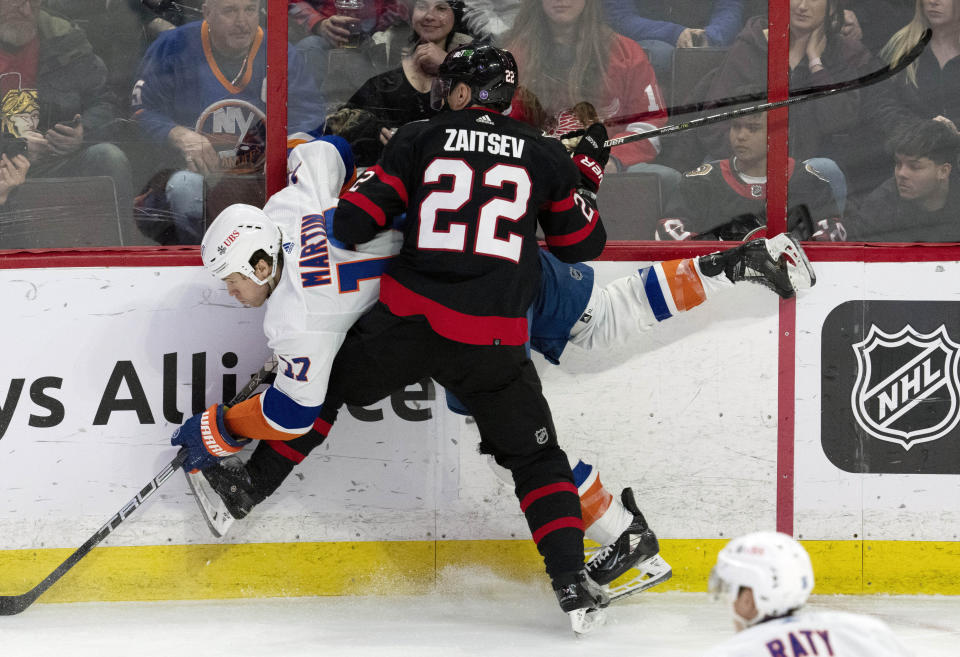 Ottawa Senators defenseman Nikita Zaitsev collides with New York Islanders left wing Matt Martin along the boards during the third period of an NHL hockey game, Wednesday, Jan. 25, 2023 in Ottawa, Ontario. (Adrian Wyld/The Canadian Press via AP)